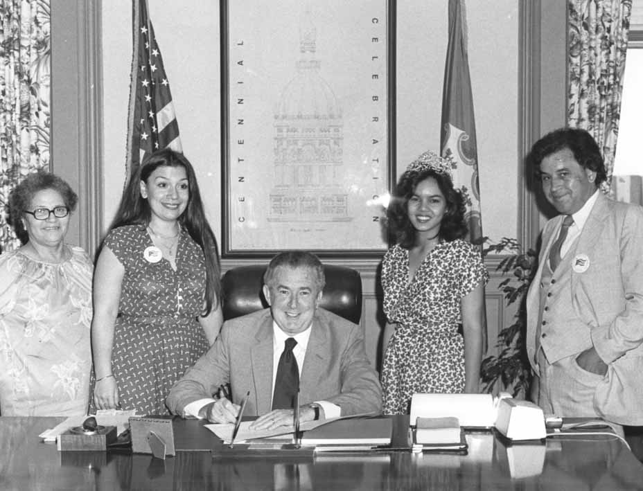 B&W 8X10 dated: 8/8/1981 Governor O'Neill signing an official statement for Puerto Rican Week. Left to right: Maria Sanchez of Hartford, Carmen Lopez, President of the Puerto Rican Parade,Gov. O'Neill, Leslie Laguna of New Haven, Puerto Rican Parade State Queen, Juan Soto of Milford, Grand Marshall.