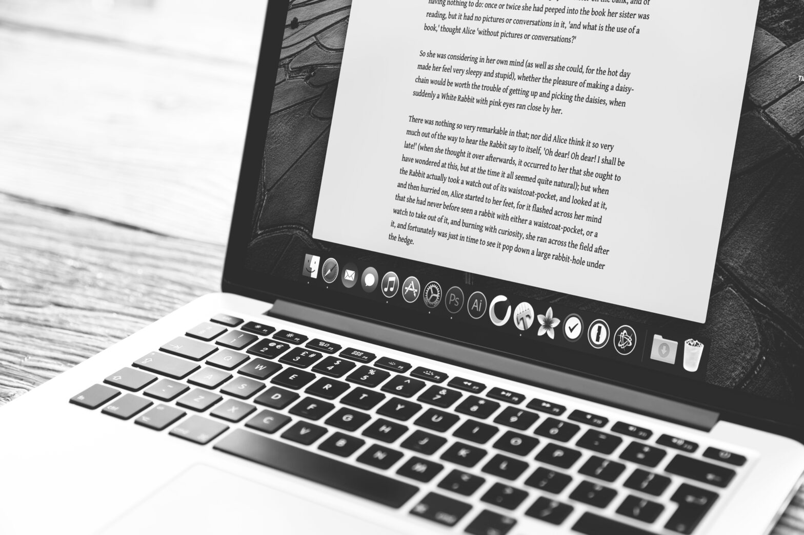 B&W Image of Laptop computer with a paper being written on its screen, thanks to Dan Counsell at Unsplash